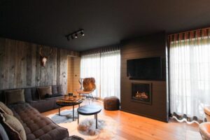 salon de la location vacances pour 6 personnes avec feu de cheminée et baie vitrée donnant sur la terrasse