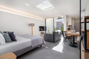 studio avec côté chambre, séjour avec canapé lit et un coin repas incluant une petite cuisine