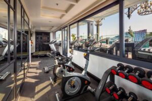 salle de fitness avec vue sur la piscine et les toits de la ville de Hanoï
