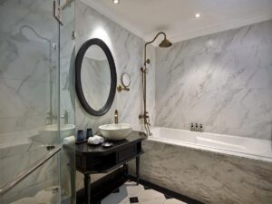 salle de bain tout en marbre blanc et mobilier noir la rendant très élégante