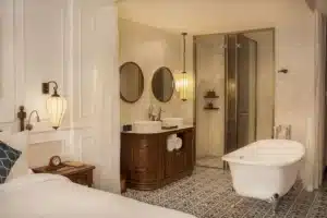 salle de bain ouverte sur la chambre pouvant se fermer avec un système de voilage pour préserver l'intimité