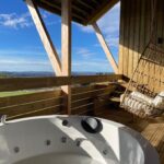 jacuzzi et fauteuil suspendu sur la terrasse du chalet