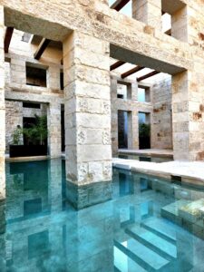 piscine de l'hôtel avec à côté le bar et l'espace petit déjeuner