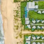 vue aérienne de l'hôtel et de la plage où les chambres sont des villas individuelles