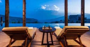 transats sur la terrasse face à la piscine à débordement d'une villa privée de l'hôtel