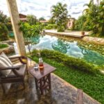 terrasse privée d'une chambre avec vue sur la piscine en forme de rivière