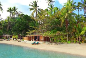 bungalow les pieds dans l'eau sur une plage d'une île privée occupée par un hôtel dans les îles Fidji en Océanie