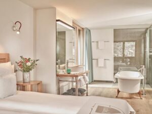 chambre d'une suite avec salle de douche et baignoire ouverte sur la chambre