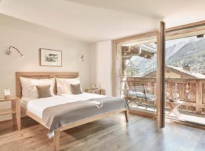 chambre de la suite junior avec son balcon et sa vue sur les montagnes
