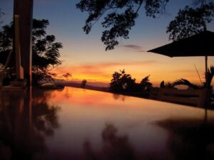 piscine à débordement de l'hôtel sous le coucher de soleil