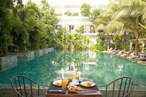 petit déjeuner au bord de la piscine de l'hôtel et au milieu de la végétation luxuriante en plein cœur de Phnom Penh