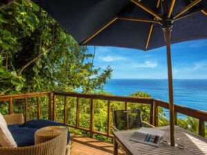terrasse d'une cabane nichée dans la végétation et avec vue panoramique sur l'océan
