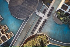vue aérienne de l'hôtel avec ses immenses piscines et transats flottant sur l"eau