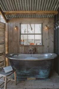 baignoire ouverte sur l'extérieur dans une des cabanes à louer