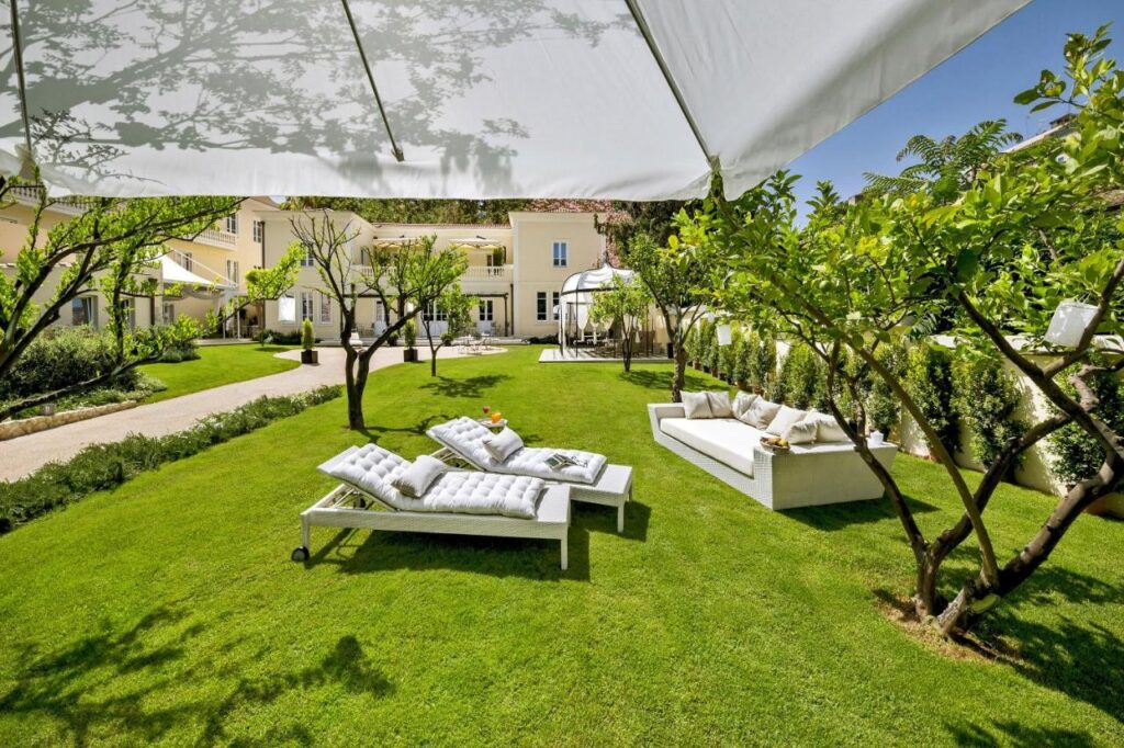 jardin magnifiquement vert et entretenu avec différents coins salon ou se poser pour bouquiner, se reposer ou prendre un verre