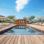 piscine avec terrasse et transat à l'hôtel Jiva Hill Resort dans le Haut-Jura