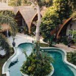 vue aérienne de la piscine et des chambres sous forme de bungalow à l'hôtel Hani Hideway dans les îles Gili en Indonésie