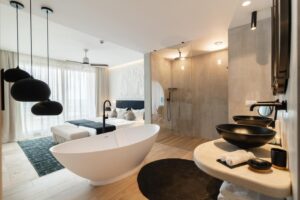 salle de bain avec douche et baignoire ouverte sur la partie chambre de la suite
