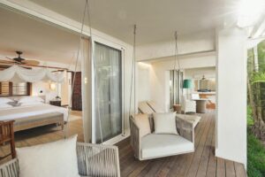 grande terrasse d'une suite avec des transats et des fauteuils balancoires