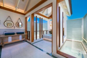 grande salle de bain avec baignoire et hamac suspendu au dessus du lagon
