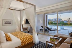 chambre premium à la décoration élégante et cosy avec transats sur la terrasse et accès direct à la piscine