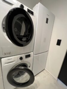 buanderie avec frigo, lave-linge et sèche-linge