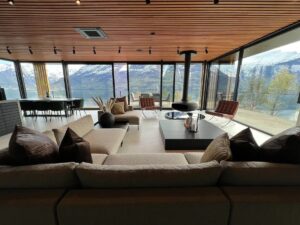 salon avec baie vitrée panoramique sur la terrasse, le fjord et les montagnes des Alpes de Romsdal