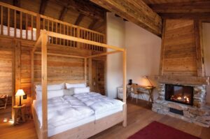 une suite romantique dans un chalet de montagne authentique avec une belle cheminée en pierre dans la chambre