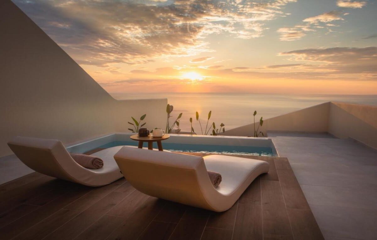 Merveilleux coucher de soleil sur Santorin depuis la terrasse privée d'une suite du Pnoe Luxury Suites
