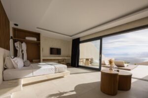 suite disposant d'une kitchenette et d'une terrasse avec piscine privée offrant une vue panoramique jusqu'à la mer Égée