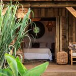 chambre double ouverte sur la terrasse abritant le salon de ce lodge éco-responsable à louer sur l'île de Grande-Terre en Guadeloupe