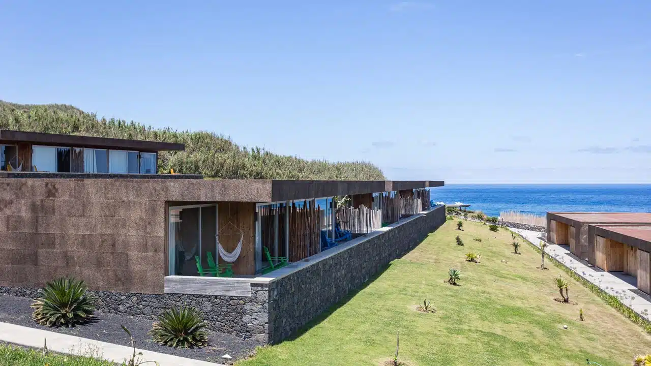 Vue extérieure des villas et de leur terrasse. Le bâtiment est construit pour se fondre dans le paysage de l'île avec son toit terrasse