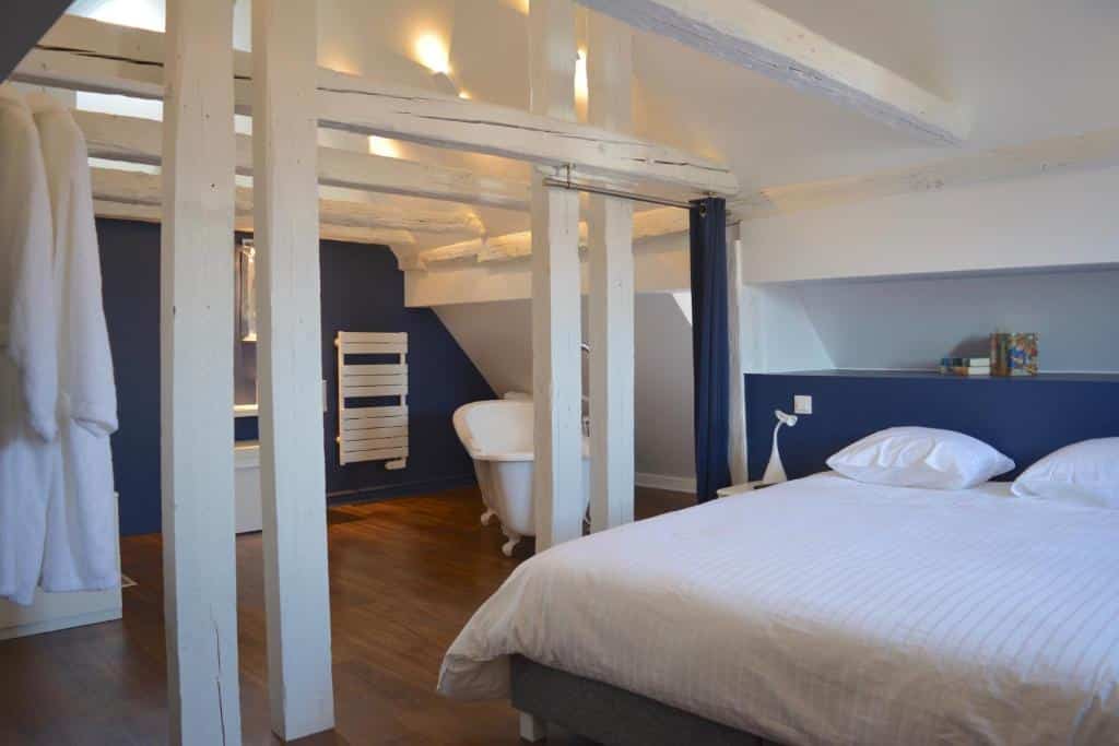 chambre avec beaucoup de cachet avec sa salle de bain ouverte et ses poutres apparentes