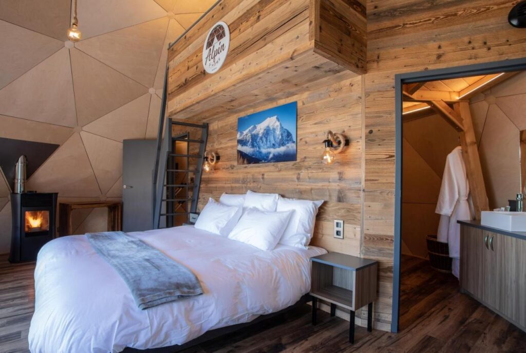 Chambre famille dans un igloo dôme avec un lit double et un escalier menant au lit des enfants