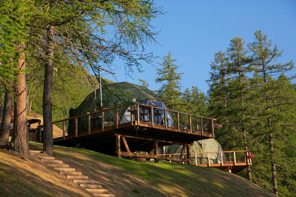 vue extérieure d'un dôme igloo avec sa terrasse en pleine montagne à l'Alpin d'Hôme aux Orres dans les Hautes-Alpes