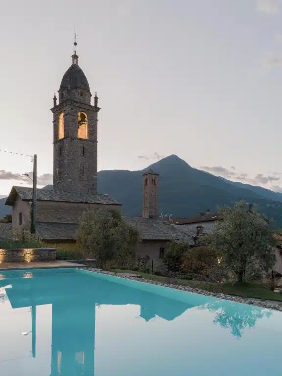 Vue sur l'église du village de Cremia depuis la piscine de l'hôtel Casa Olea