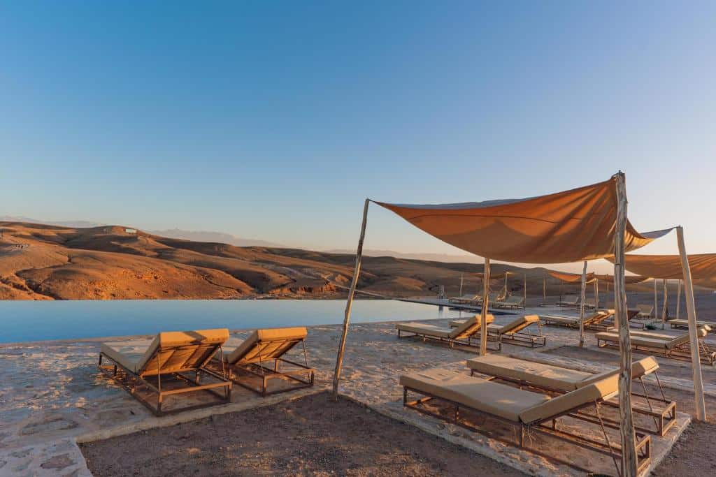 piscine et transat au coucher du soleil dans le désert d'Agafay au Maroc