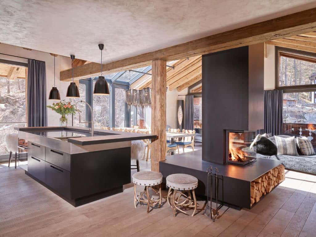 séjour avec cuisine ouverte et cheminée au feu de bois dans un appartement pour 12 personnes à l'hôtel Firefly Luxury Suites de Zermatt