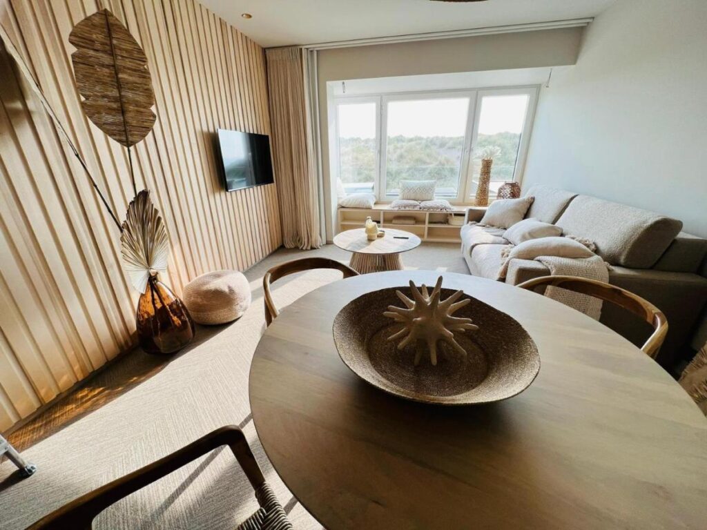 séjour avec cuisine ouverte, espace repas et coin salon avec un canapé-lit